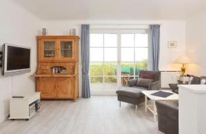 Una sala de estar con un sofá y un televisor. en Haus Heefkant Whg 5, en Rantum