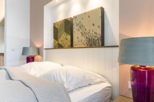 1 dormitorio con 2 camas y lámpara púrpura en Art your Life Residenz Seeburg Whg 6, en Westerland
