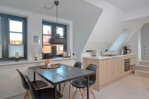 a kitchen with a table and chairs in a room at Villa Maybach Whg 8 in Westerland