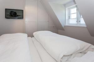 a bedroom with two white beds and a window at Villa Aegir Whg 2 in Westerland