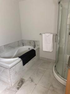 La salle de bains est pourvue d'une baignoire et d'une douche. dans l'établissement Maison Carofanne, à Saint-Siméon