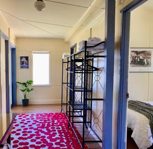a room with a ladder and a red rug at Eugenie Cottage 1930s Art Deco in Bright