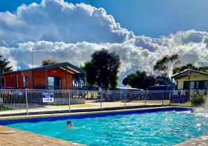 un hombre nadando en una piscina en una casa en Geelong Surfcoast Hwy Holiday Park, en Mount Duneed