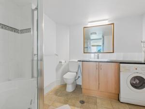 un bagno con un lavandino del water e una lavatrice di Top Floor Beachside Apartment in the Heart of Mooloolaba a Mooloolaba Altre 7 foto