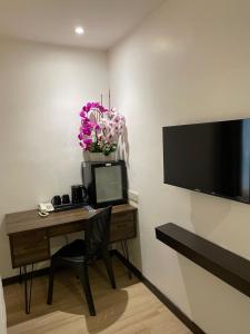 a room with a desk with a computer and a television at Geo Boutique Hotel - Seri Kembangan in Seri Kembangan