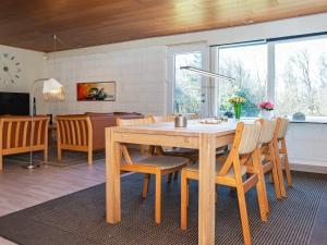 una cucina e una sala da pranzo con tavolo e sedie in legno di Holiday Home Brunbjergvej a Nørby