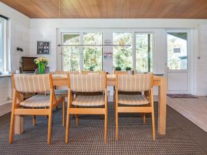 una sala da pranzo con tavolo e sedie in legno di Holiday Home Brunbjergvej a Nørby