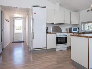 リンケビングにあるFour-Bedroom Holiday home in Hals 5の白い家電製品が備わるウッドフロアのキッチン