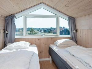 two beds in a room with a window at Three-Bedroom Holiday home in Ulfborg 23 in Fjand Gårde