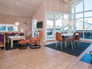 a dining room and living room with a table and chairs at Three-Bedroom Holiday home in Ulfborg 23 in Fjand Gårde