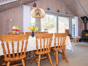 mesa de comedor con sillas y lámpara de araña en Three-Bedroom Holiday home in Ringkøbing 26, en Søndervig
