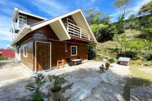 uma pequena casa com uma varanda em cima em OYO Homes 90264 Lily Cottage & Kitchen em Ranau