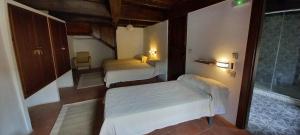 a small room with two beds and a window at Albergue Turístico "San Blas" de Oliva de Plasencia in Oliva de Plasencia