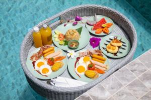 アオナンビーチにあるPoonsiri Varich Pool Villa Aonangのプールサイドのテーブルに並べた朝食用の食材