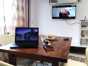 a laptop computer sitting on top of a wooden table at Апартамент "Скален венец" in Veliko Tŭrnovo