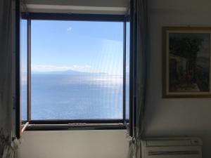 una ventana en una habitación con vistas al océano en La Casetta, en Amalfi