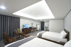 ein Hotelzimmer mit 2 Betten und einem Schreibtisch in der Unterkunft Haeundae Central Hotel in Busan