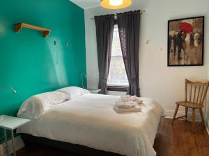 um quarto com uma cama com uma parede verde em Barefoot Inn em Ottawa