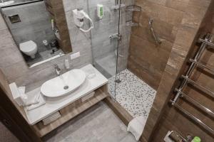 La salle de bains est pourvue d'une douche, d'un lavabo et de toilettes. dans l'établissement Alpen Park, à Togliatti
