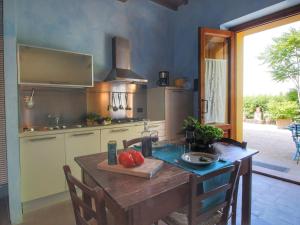 una cocina con una mesa de madera con tomates. en Belvilla by OYO Podere Pulicciano, en Castelfranco di Sopra