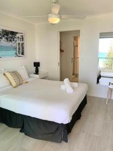 a bedroom with a large white bed with two pillows at Emerald Sands Holiday Apartments in Gold Coast