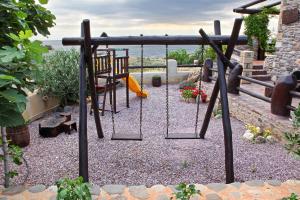 a playground with a swing and a table and chairs at Astrolithos Boutique in Monemvasia
