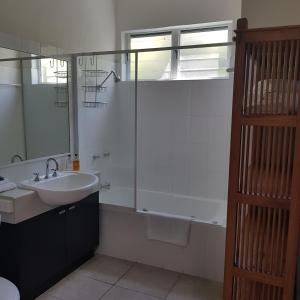 ein Badezimmer mit Dusche, Waschbecken und Badewanne in der Unterkunft Coral Sea Villas in Port Douglas + 30 Fotos