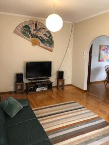 ein Wohnzimmer mit einem Sofa und einem Flachbild-TV in der Unterkunft The Red Door in Mount Gambier