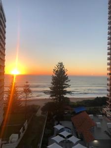 una puesta de sol sobre el océano desde un edificio en Emerald Sands Holiday Apartments, en Gold Coast