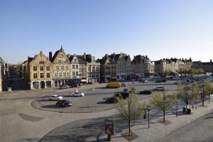 een parkeerplaats in een stad met auto's en gebouwen bij Hotel Gasthof 't Zweerd in Ieper