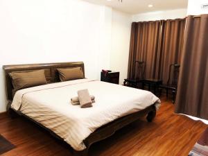 a bedroom with a bed with two towels on it at Hotel IYA in Pathum Thani