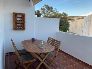 a wooden table and chairs on a balcony at Casa Barbados en Agua Amarga in Agua Amarga