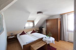 a bedroom with a large bed and a table at Wellenhof Bodensee in Lochau