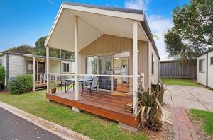 Casa con terraza grande con mesa en Ocean Grove Holiday Park, en Ocean Grove