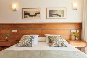 a bedroom with a bed with two pillows at Hostal la Savina in La Savina