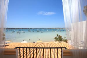 a view of a beach with boats in the water at Hostal la Savina in La Savina