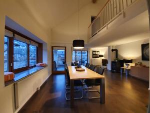 comedor y sala de estar con mesa y sillas en Luxuriöses Galerie-Penthouse direkt am Walensee en Unterterzen