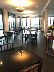 巴吞他尼Hotel IYA的有桌椅和窗户的餐厅