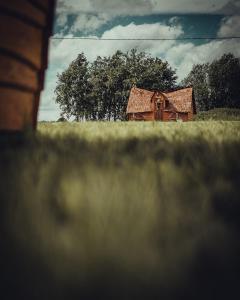 Ein altes Haus mitten auf einem Feld in der Unterkunft külalistemaja Kadrina mõisa kämpingud in Kadrina