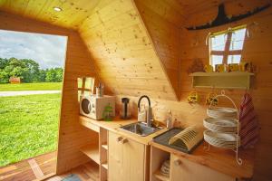 eine Küche in einem Blockhaus mit einem Waschbecken und einem Fenster in der Unterkunft külalistemaja Kadrina mõisa kämpingud in Kadrina