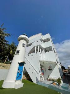 a white building with a lighthouse on the grass at 恆春洋蔥風格旅居 onion in in Hengchun