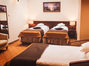 pokój hotelowy z 3 łóżkami i lustrem w obiekcie Hotel Osjann w Białej Podlaskiej