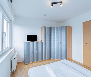 1 dormitorio con 1 cama y TV en la pared en Hotel Tannenblick, en Bad Vilbel