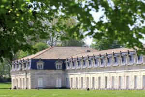 a large white building with a brown roof at The Originals Boutique, Hôtel Roca-Fortis, Rochefort in Rochefort