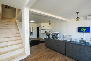 sala de estar de planta abierta con escaleras y cocina en Central Apartments, en Kladovo