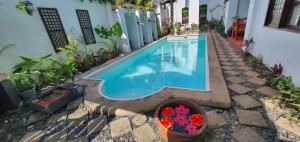 a swimming pool in front of a house at RedDoorz Plus @ Evangeline Beach Resort in Pagudpud