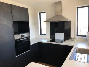 a kitchen with black cabinets and a sink at The Drydock in Stratford