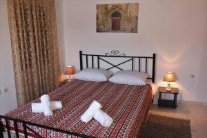 a bedroom with a bed with two rolled towels on it at Traditional Stone house in Rhodes Town