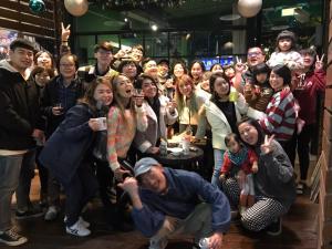 Un grand groupe de personnes se posant pour une image dans l'établissement Travel Charger Hostel, à Hualien