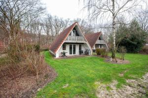 una casa con techo de gambrel en un patio en Stijlvolle vakantiewoning just for holliday, en Gramsbergen